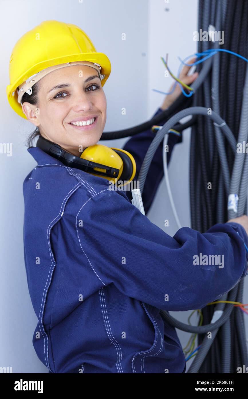 female electrician working with wire pipes Stock Photo