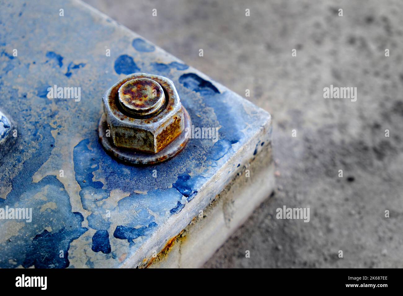Strong large bolt and nut securing metal to ground strength Stock Photo