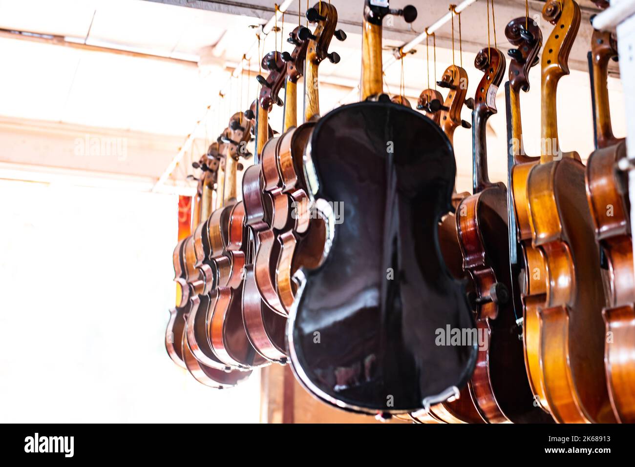 Violins are hanging in retail store to sell Stock Photo