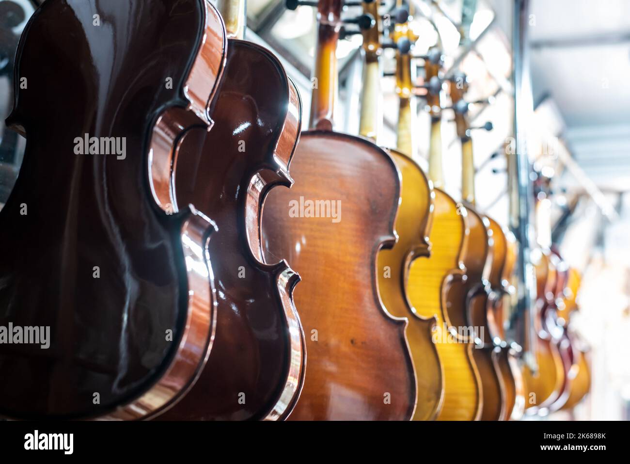 Violins are hanging in retail store to sell Stock Photo