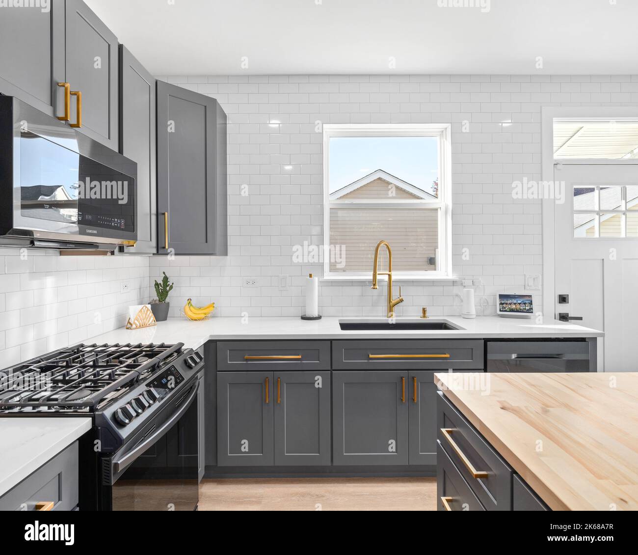 Stainless grey metal kitchen gas stove installed on a the kitchen with a  dark grey table top Stock Photo - Alamy