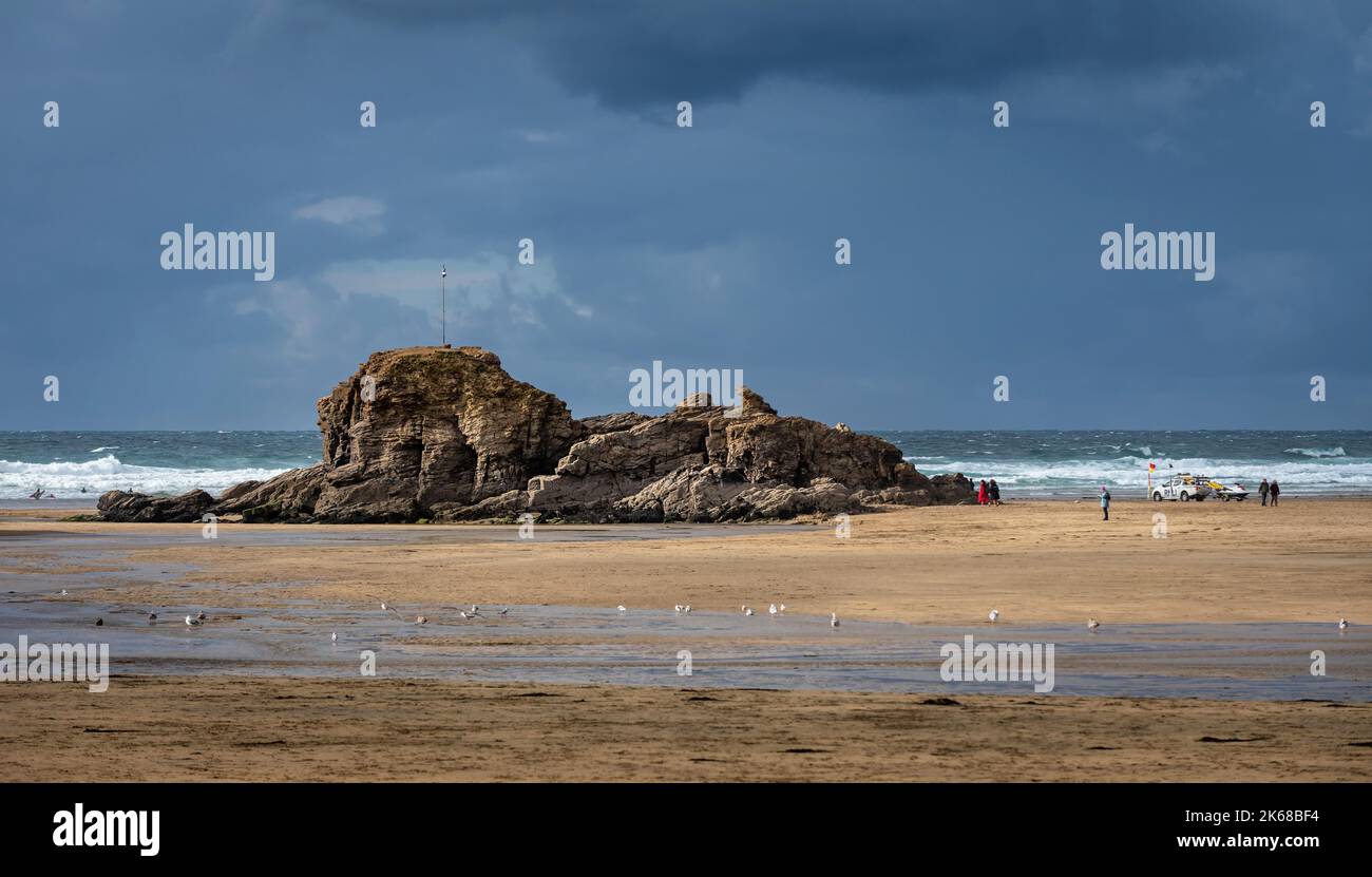 Rock formation on Perranporth beach in Cornwall. RNLI vehicle near sea Stock Photo