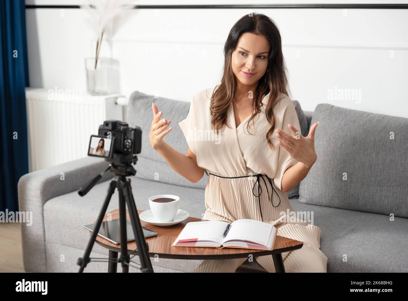 Young, beautiful woman broadcasting fashion tutorial. Internet content creator working from home Stock Photo
