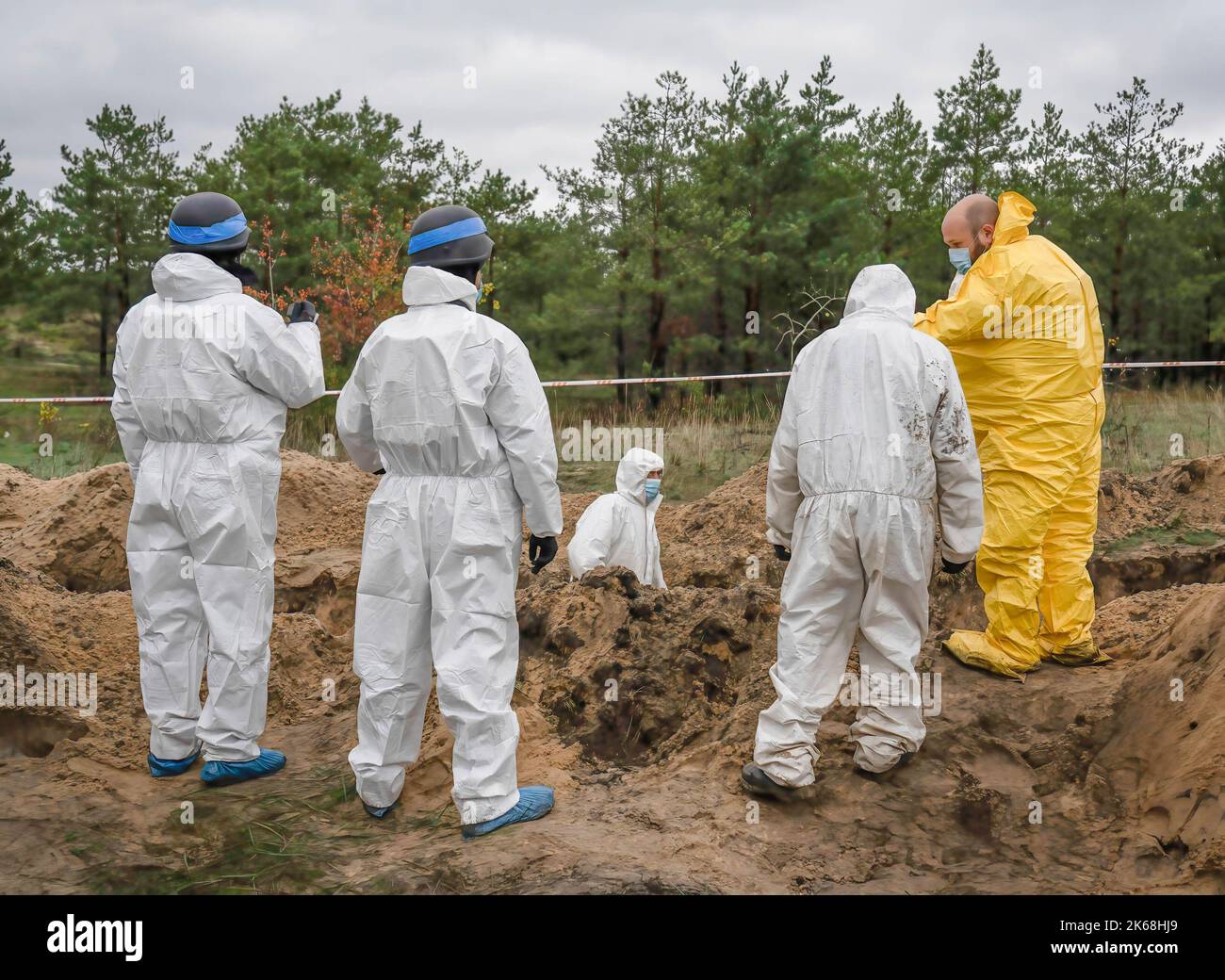 Investigators wearing protective gears are seen exhuming Ukrainian soldiers' bodies from a burial site in Lyman. At least 32 Ukrainian soldiers’ bodies have been exhumed from a mass grave in Lyman, a city in Donetsk region that was under Russian occupation. Authorities said they were buried together and initial investigation has shown some bodies were blindfolded and tied on the hands, which suggested signs of torture and execution. Another 22 civilians, including children were exhumed from another burial site nearby. Both sites located at the edge of a cemetery. Officials said they are expect Stock Photo