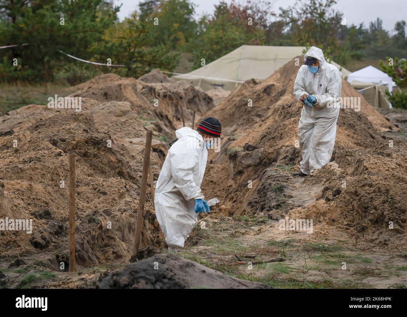 Investigators wearing protective gears are seen exhuming Ukrainian soldiers' bodies from a burial site in Lyman. At least 32 Ukrainian soldiers’ bodies have been exhumed from a mass grave in Lyman, a city in Donetsk region that was under Russian occupation. Authorities said they were buried together and initial investigation has shown some bodies were blindfolded and tied on the hands, which suggested signs of torture and execution. Another 22 civilians, including children were exhumed from another burial site nearby. Both sites located at the edge of a cemetery. Officials said they are expect Stock Photo