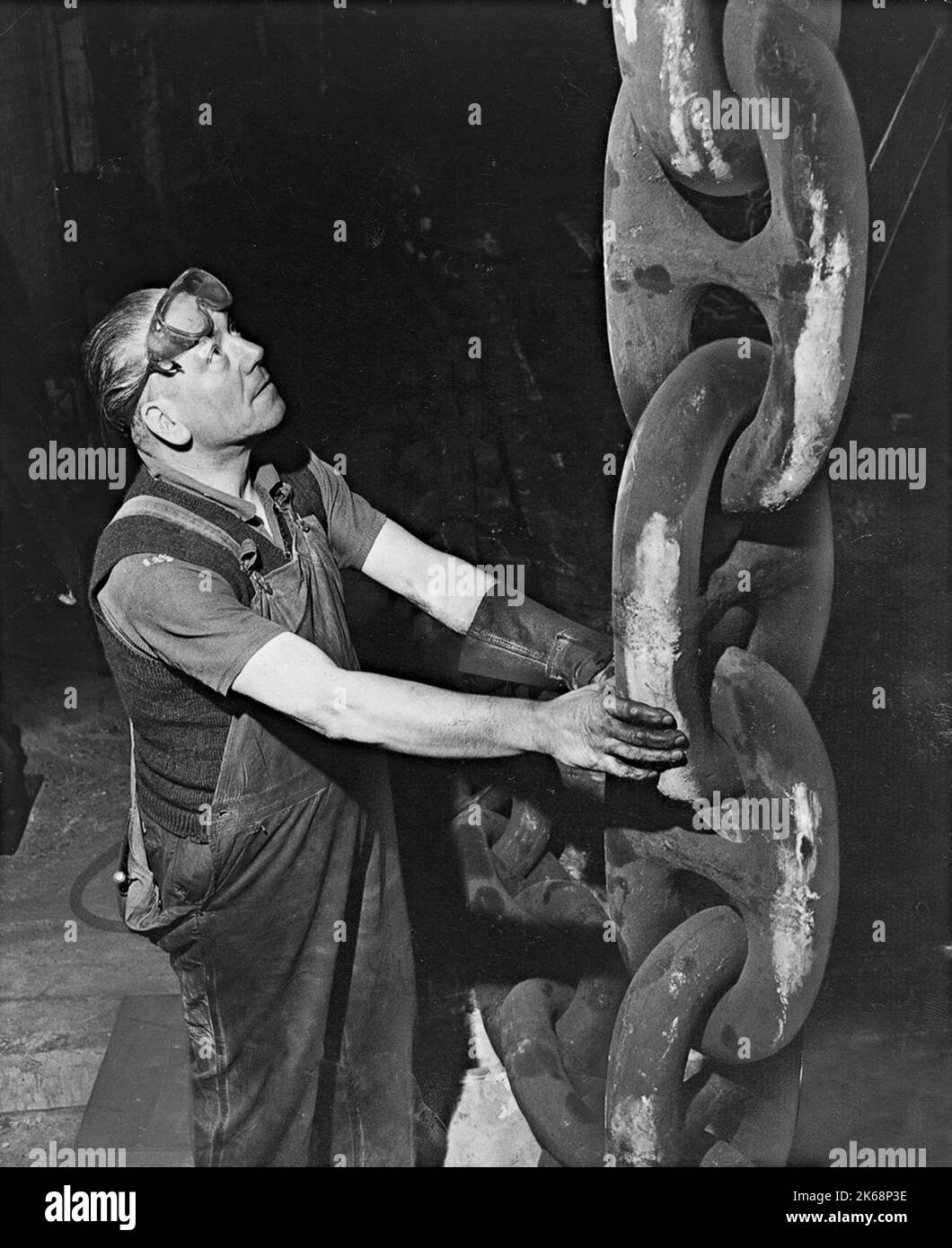 Chain maker Vic Hill with the anchor chain for Q4 ocean liner at British Tayco factory in Brierley Hill in 1966 Stock Photo