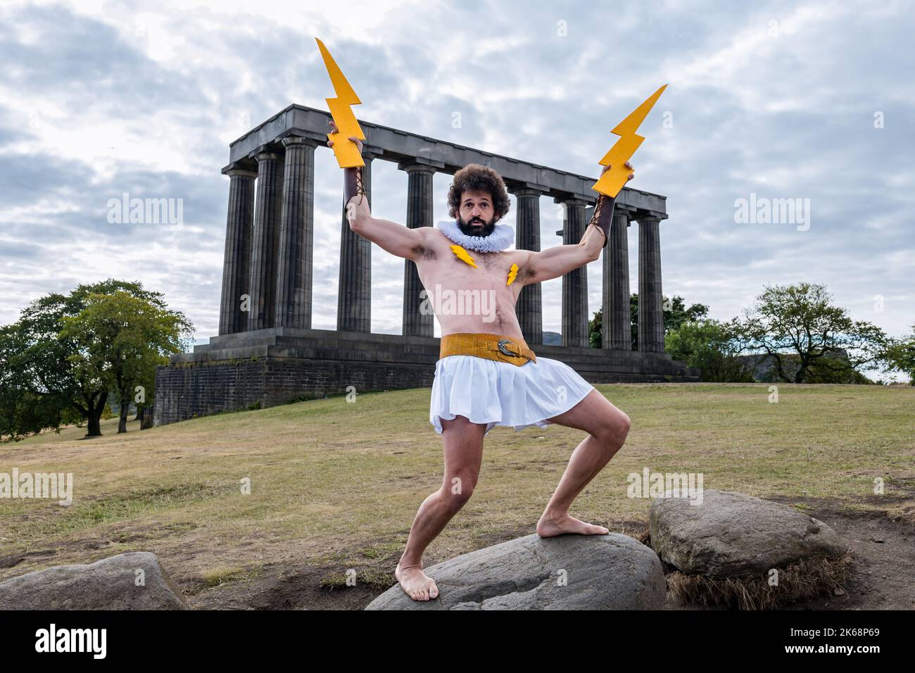 Fringe performer Garry Starr aka Damien Warren-Smith as Greek God Zeus with lightning bolts, Calton Hill, Edinburgh, Scotland,UK Stock Photo