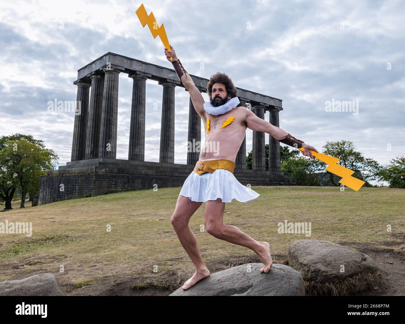 Fringe performer Garry Starr aka Damien Warren-Smith as Greek God Zeus with lightning bolts, Calton Hill, Edinburgh, Scotland,UK Stock Photo