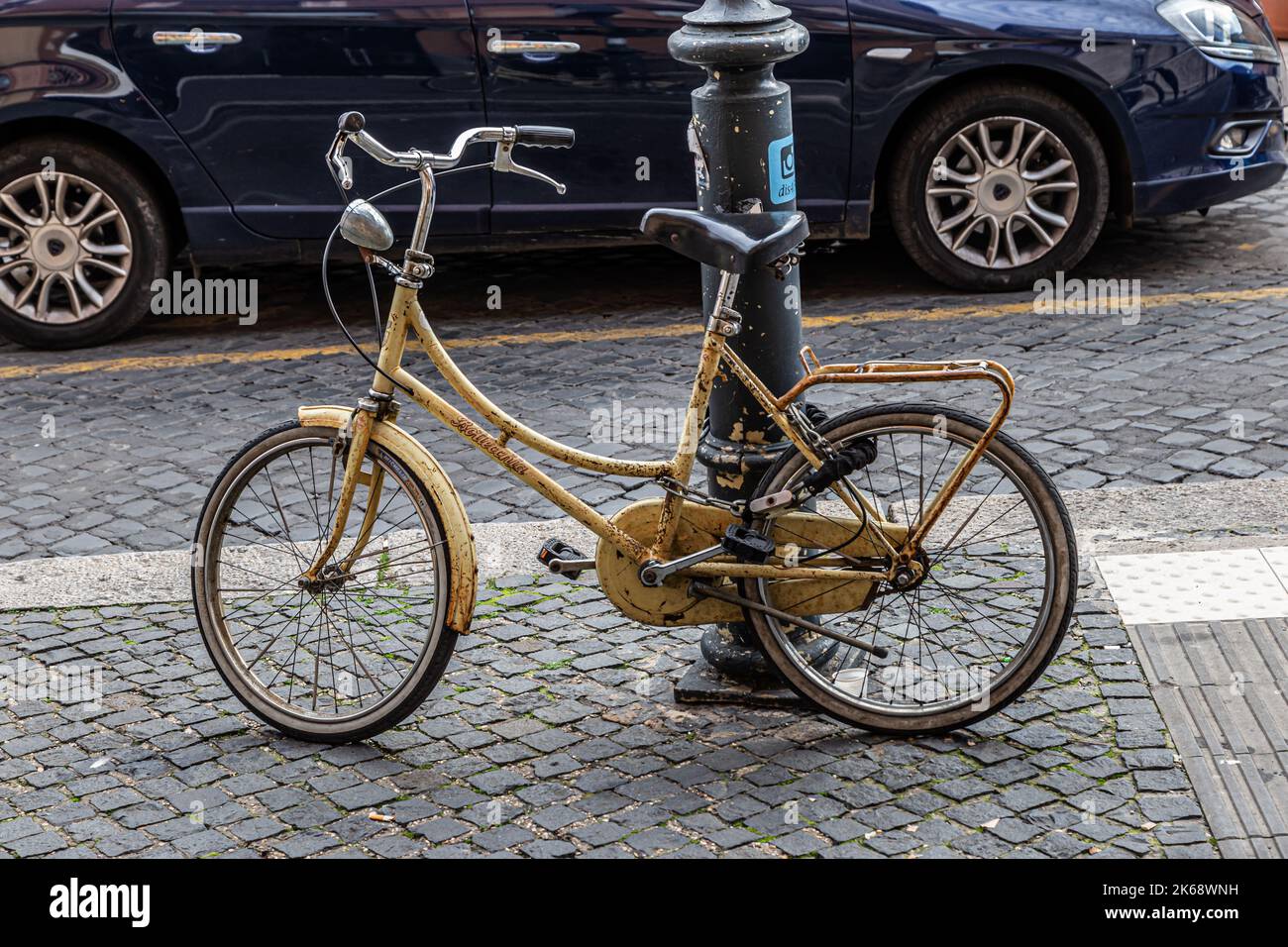 Rome, Italy - December 06, 2019:  Old yellow bicycle parked in the city center in Rome, Italy Stock Photo