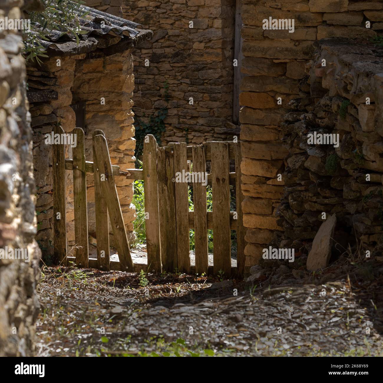 a traditional wooden slatted gate and small fence at the entrance to a