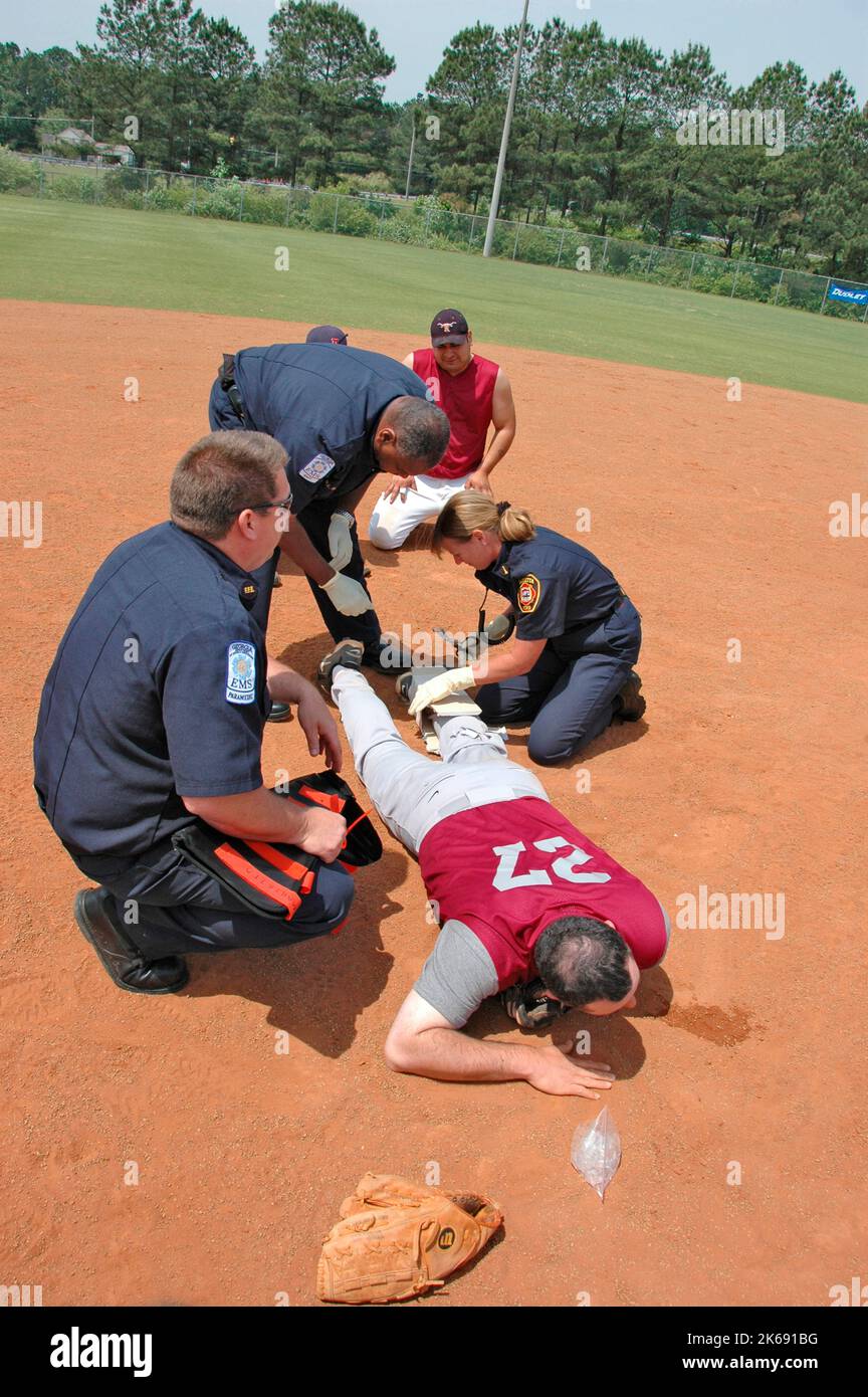 softball Player with broken leg is attended to by fire personal and