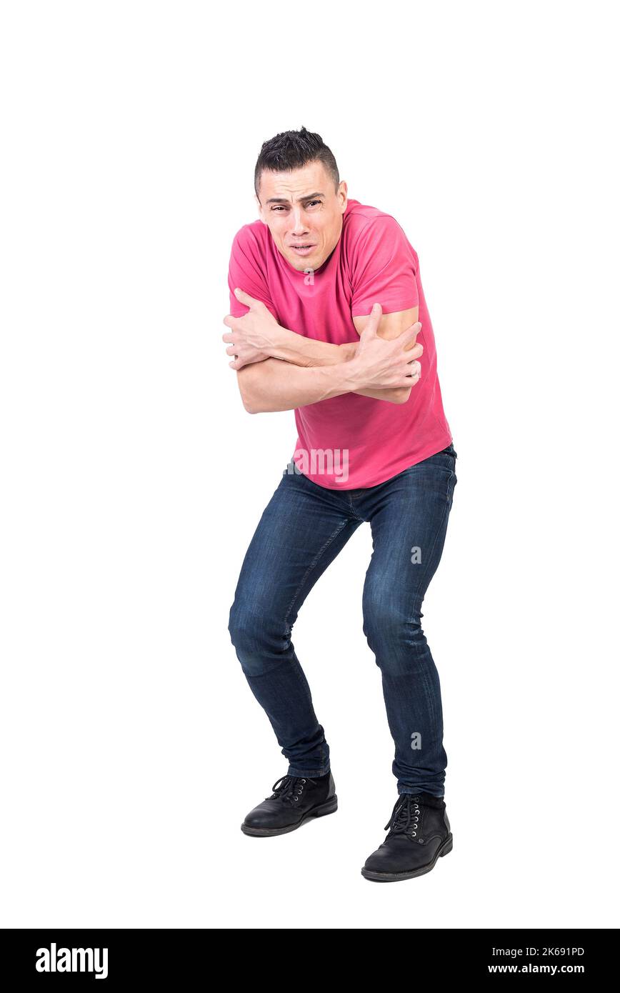 Shivering man standing in studio with crossed arms Stock Photo