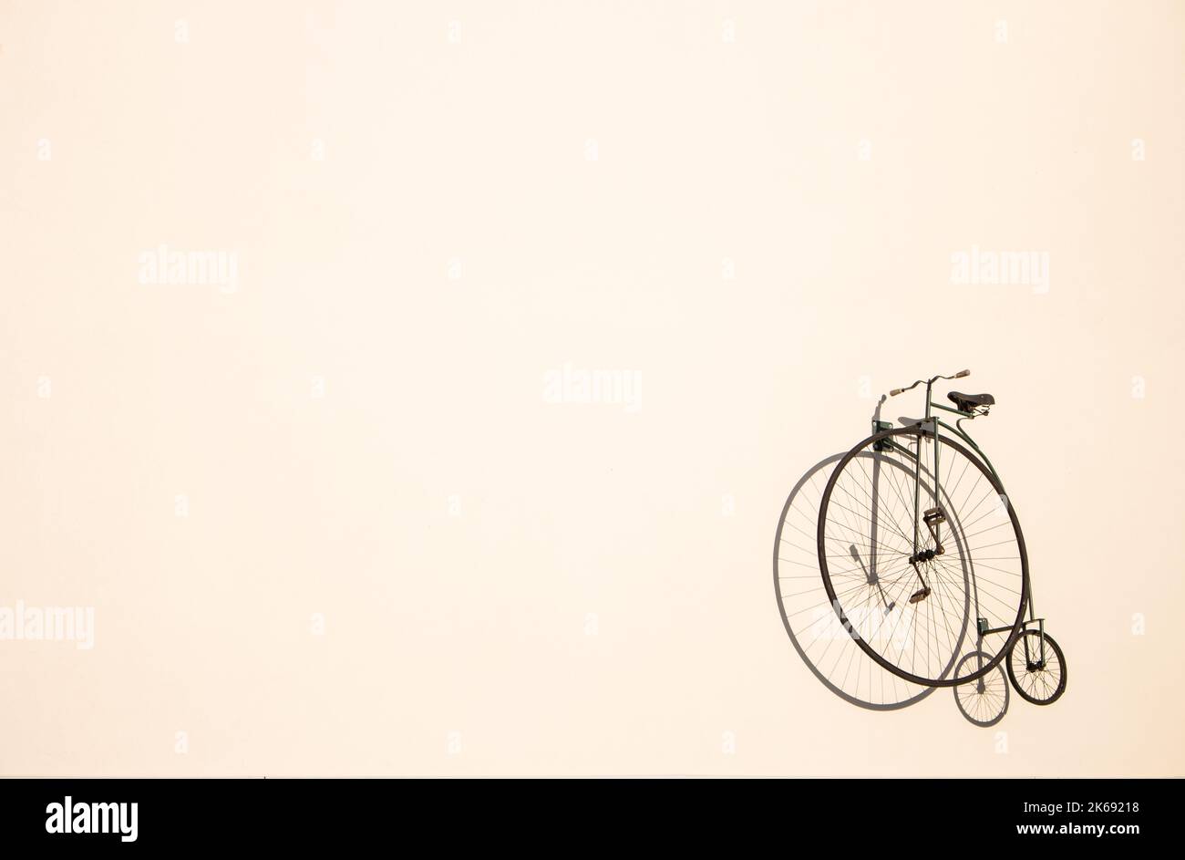 Retro bicycle silhouette on the wall with copy space. Transportation concept. Old bike with big wheel. Minimalism concept. Stock Photo