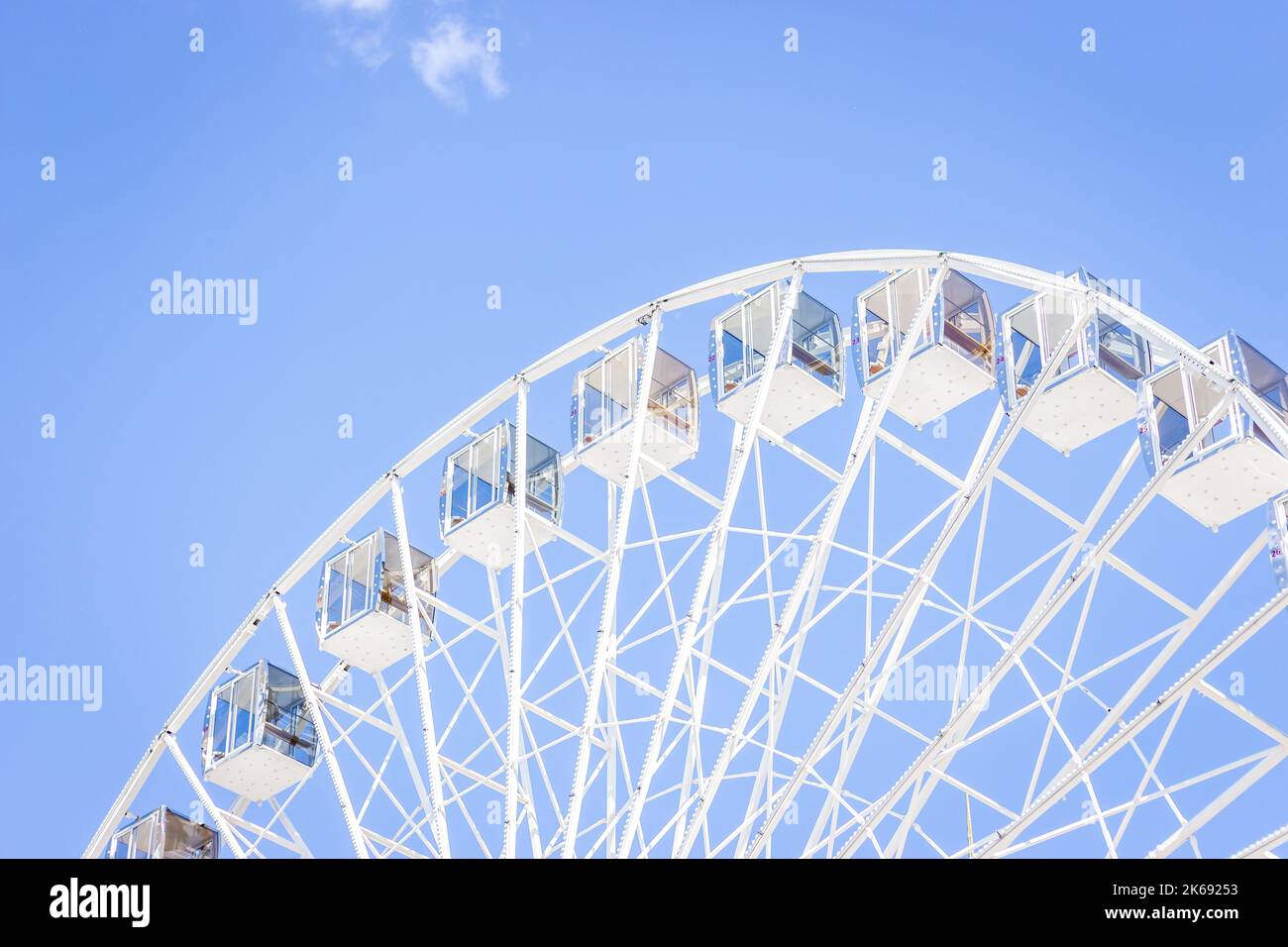 Ferris wheel on a blue sky. Amusement park. Empty ferris wheel on sunny day in Kyiv, Ukraine. Summer recreation. Leisure activity. Minimalism. Stock Photo