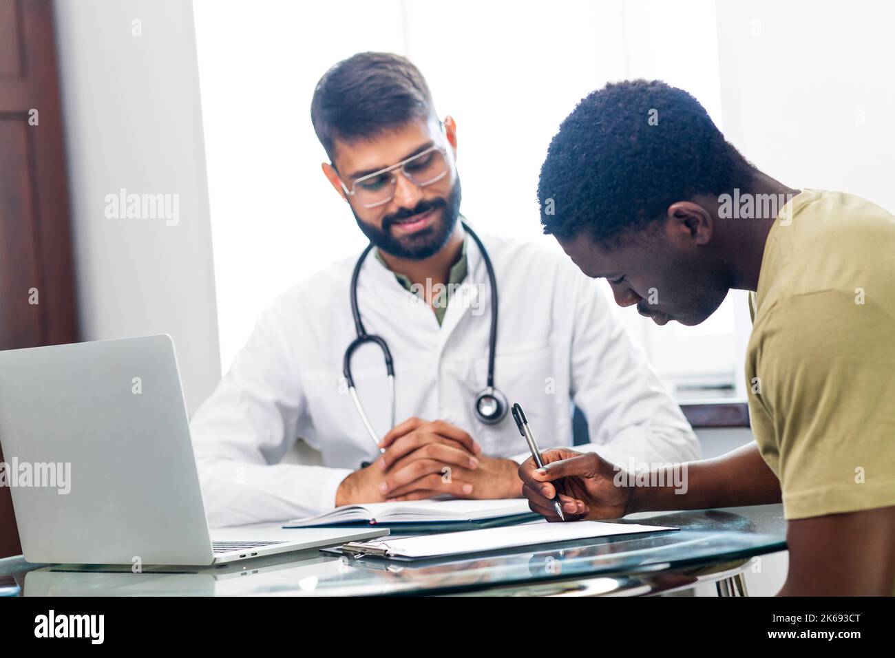 Indian doctor therapist in white coat consulting supporting patient in modern clinic hospital