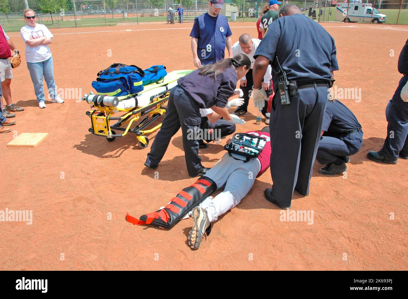 softball Player with broken leg is attended to by fire personal and