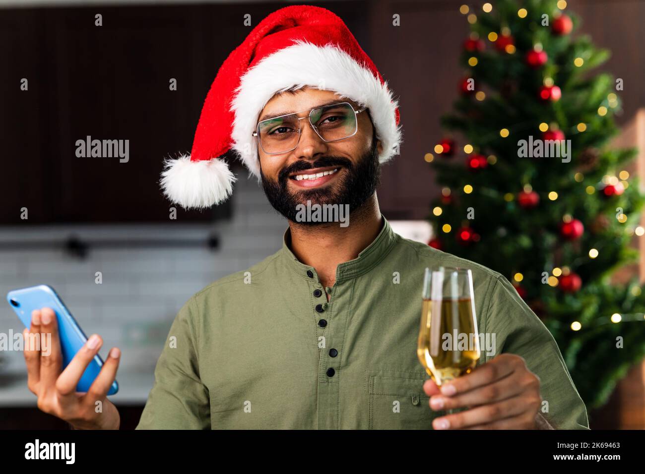 indian man drinking alcohol at home Christmas tree lights garland
