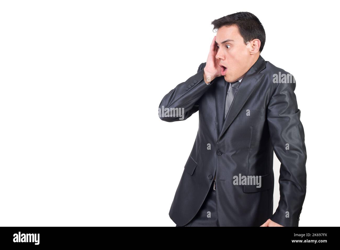 Astonished man in suit touching cheek in studio Stock Photo