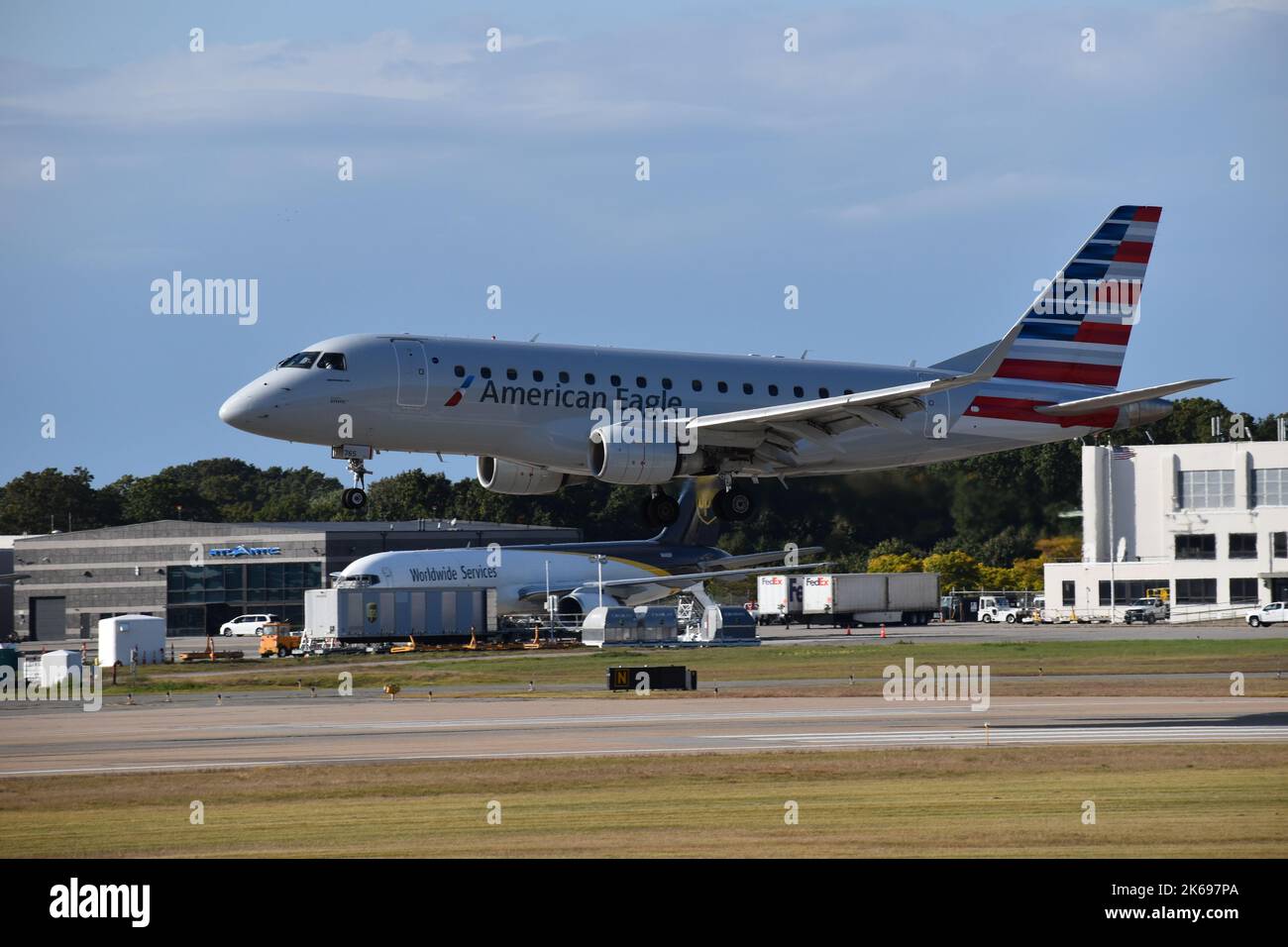 An American Embraer landing at T.F. Green Airport with buildings and