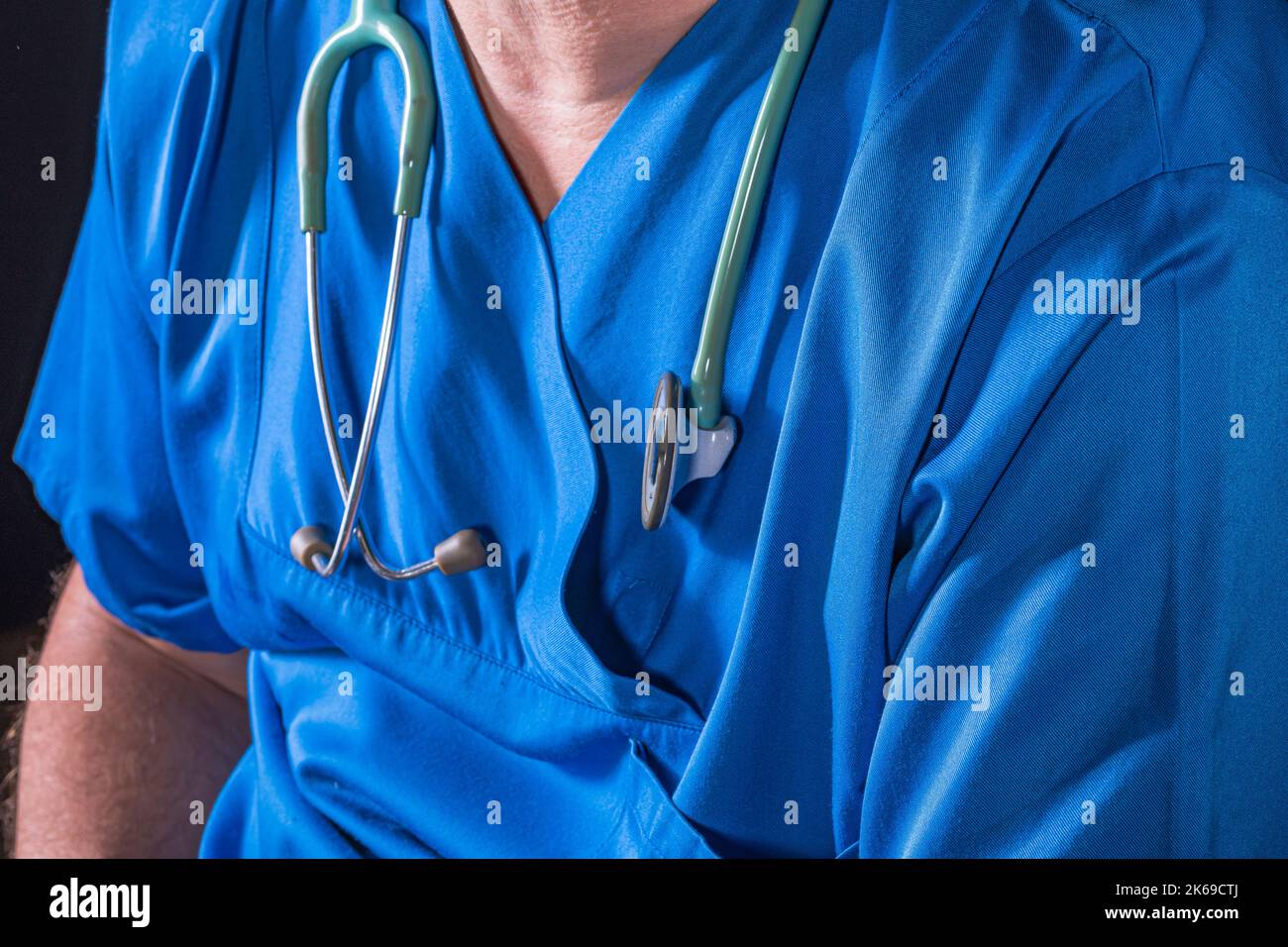 mature doctor with a beard dressed in a blue operating room suit on a