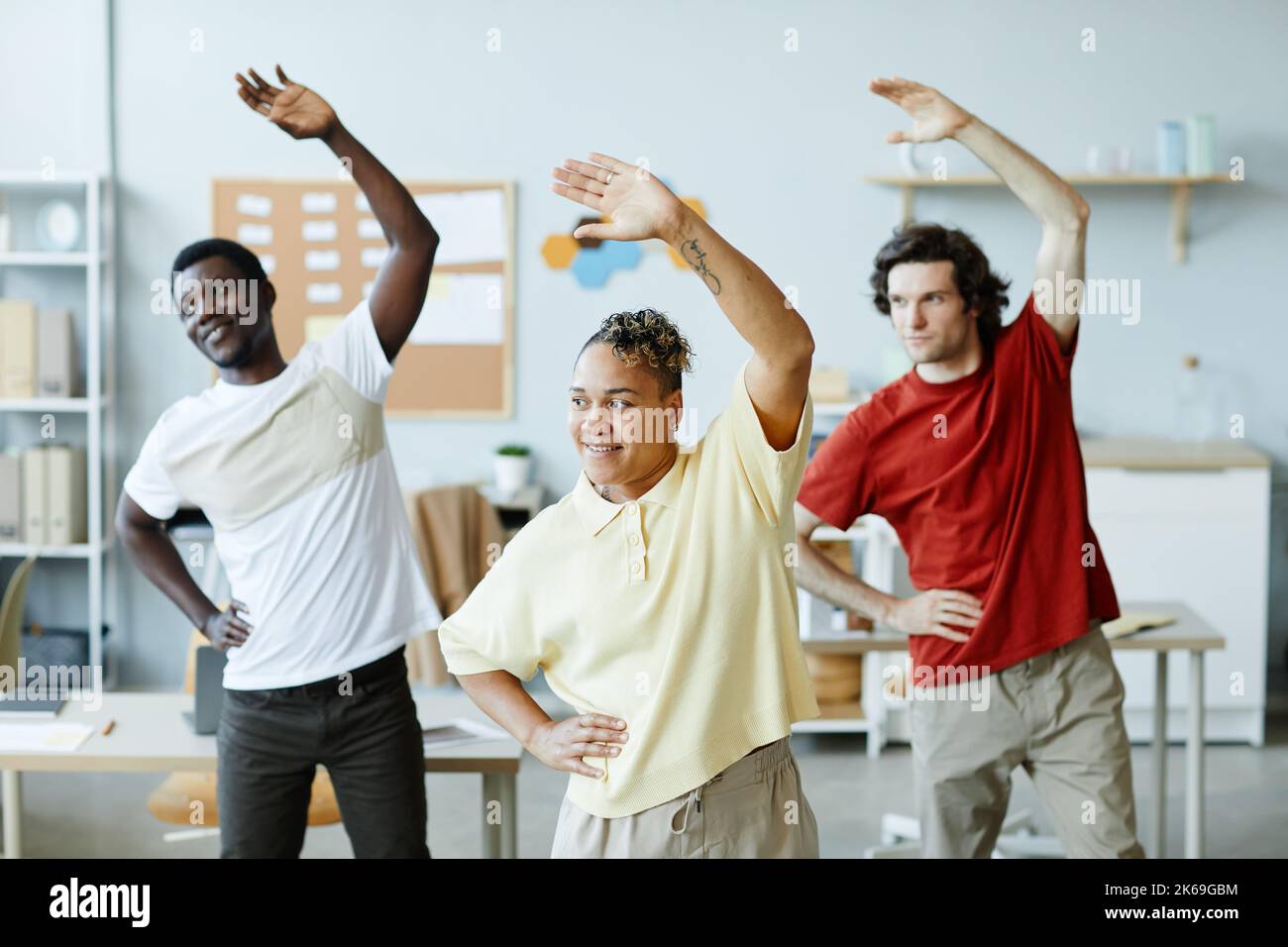 Diverse group of young people doing stretching exercises during warm up