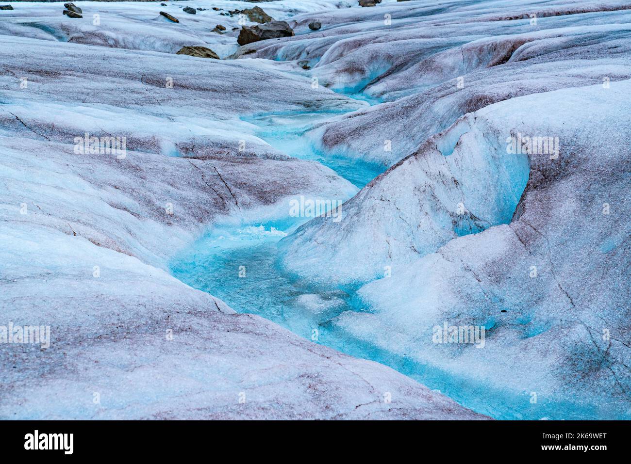 Melting glacier ice in the Mendenhall Glacier in Alaska forms a winding stream of crystal clear blue water Stock Photo