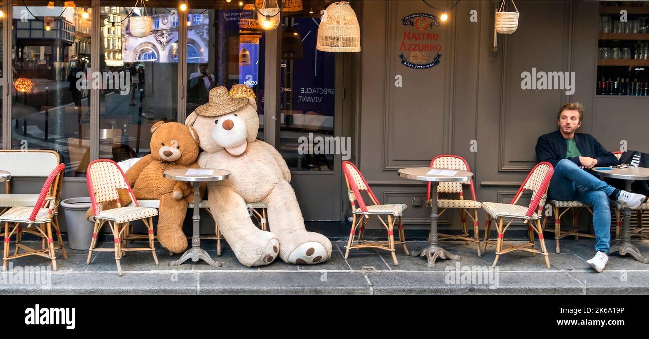 Two giant bears keep a man company at a Cafe in Paris, France during the Covid-19 pandemic Stock Photo