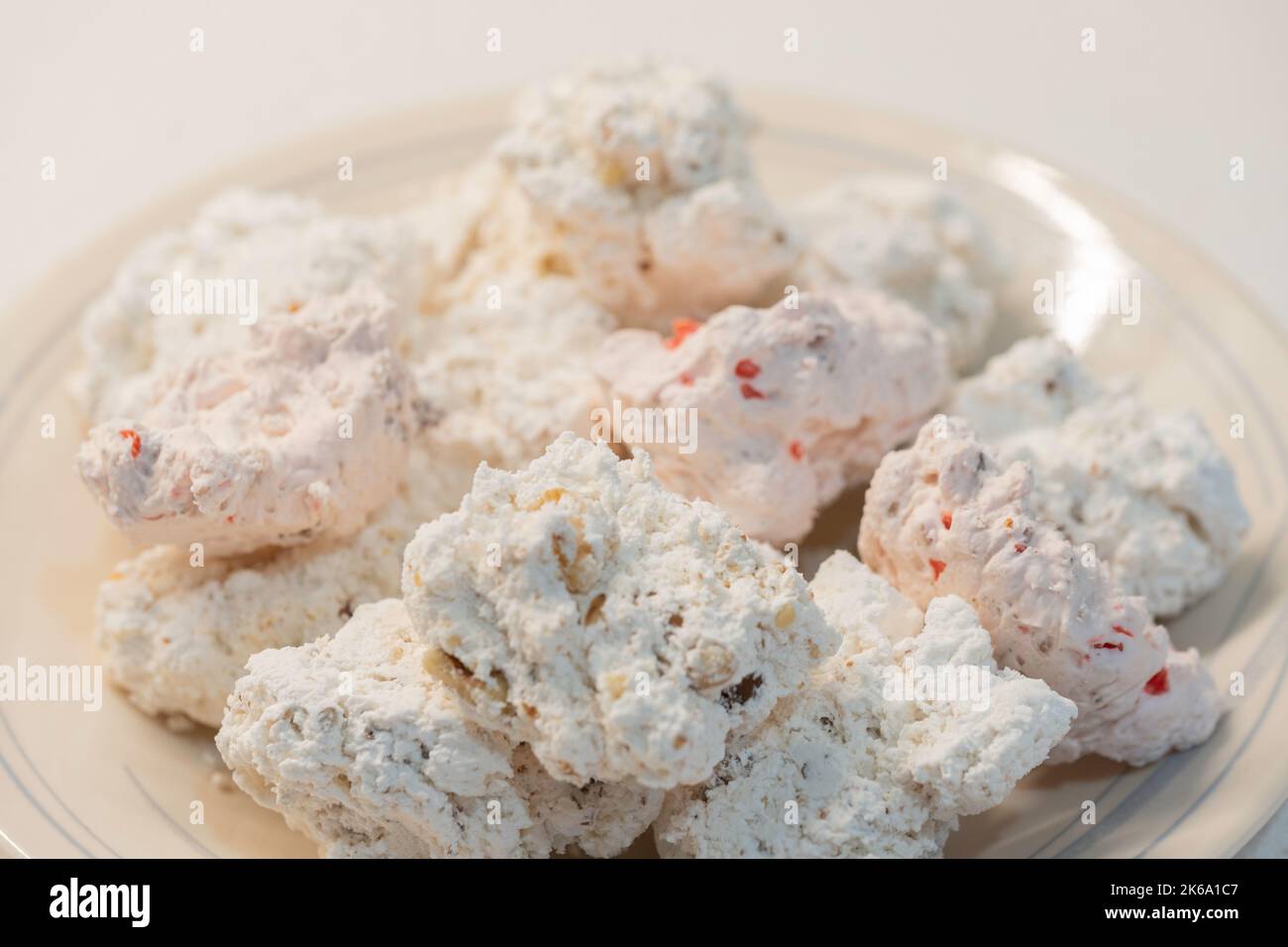 Homemade divinity candy, a mix of pecan and cherry pecan divinity in a plate sat on a white tcountertop. USA. Stock Photo