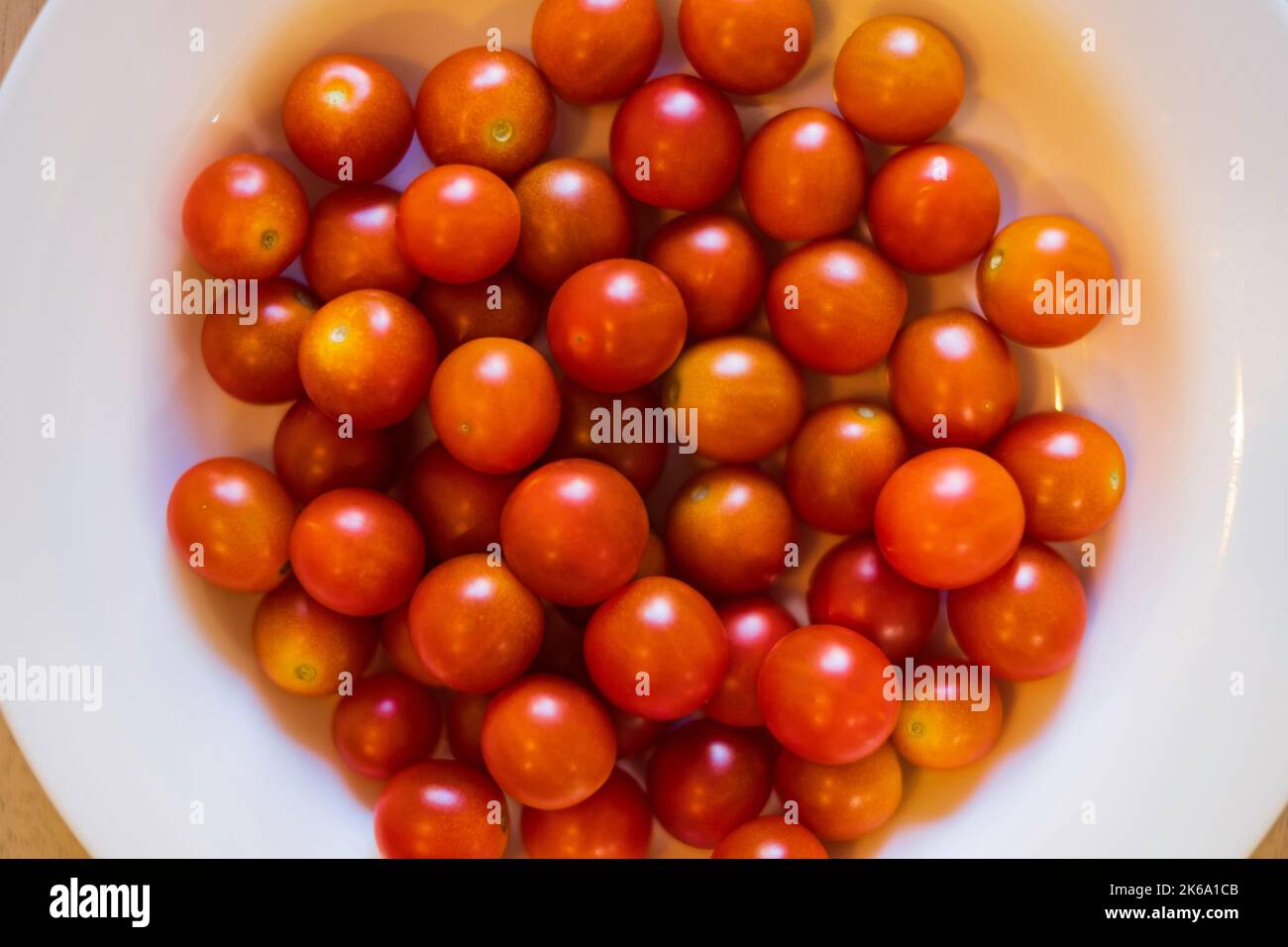 Cherry tomatoes also known as grape tomatoes. Home grown. Indeterminate, hybrid cultivar. Super Sweet 100 variety. Kansas, USA. Stock Photo