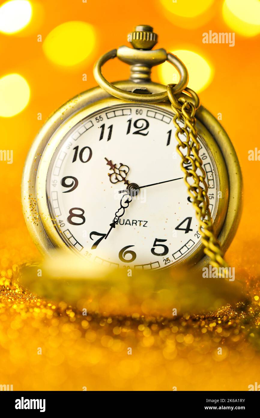 Christmas and New Year time.Golden watch in gold glitter with shining bokeh.holiday time.Christmas wallpaper.Holiday lights.Beautiful background in Stock Photo