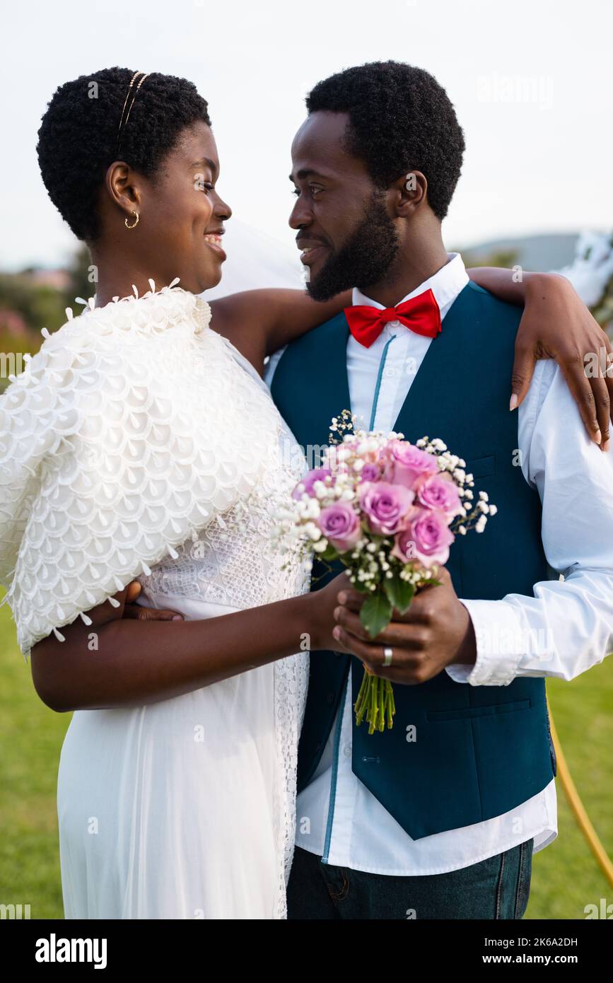 Happy african american couple holding hands and embracing during ...