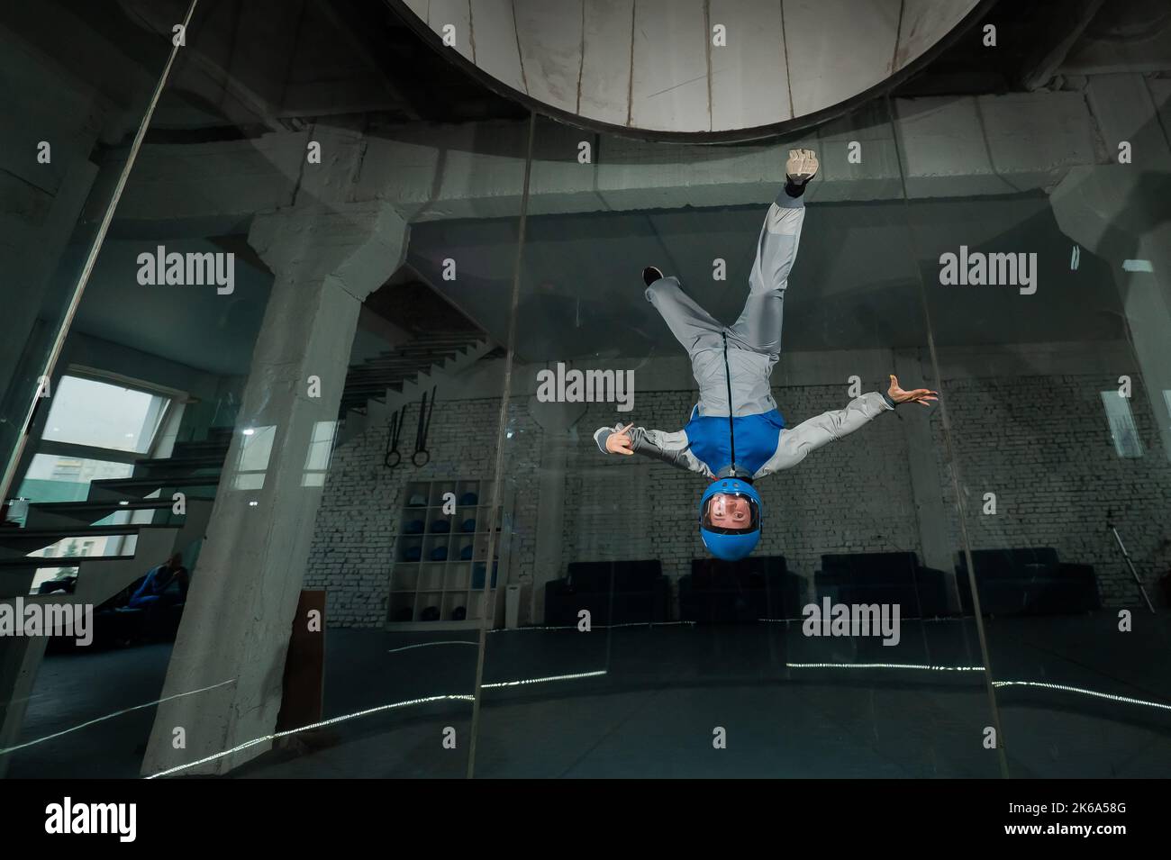 A woman flies in a wind tunnel. Free fall simulator Stock Photo - Alamy