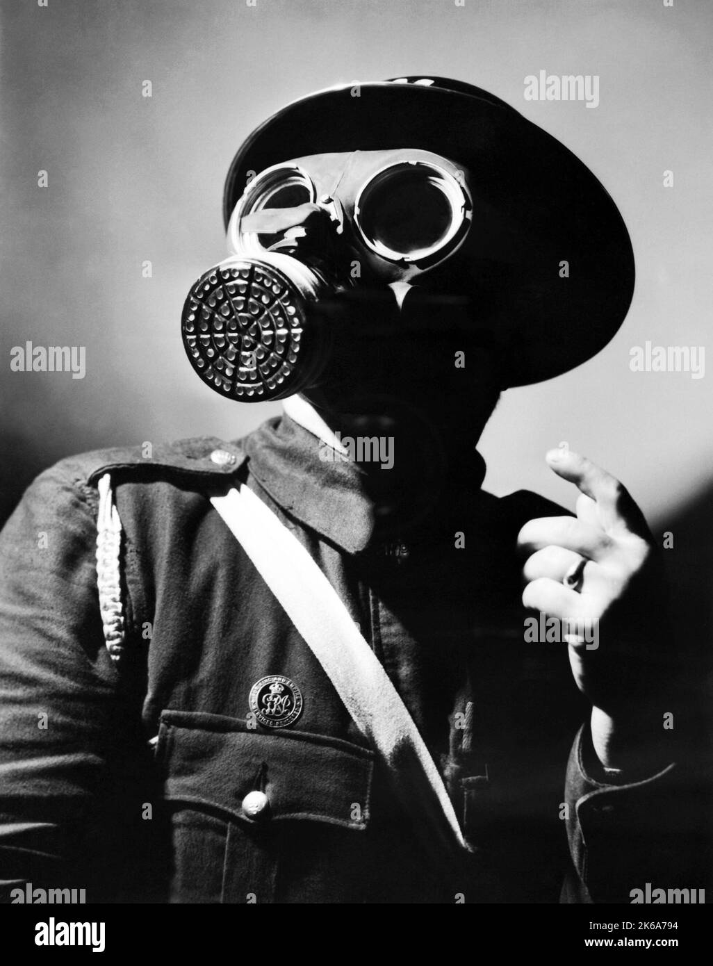 Portrait of an Air Raid Warden wearing a steel helmet and gas mask during World War II. Stock Photo