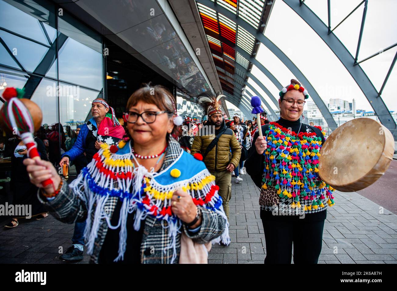 Two Indigenous women are seen playing traditional instruments during ...