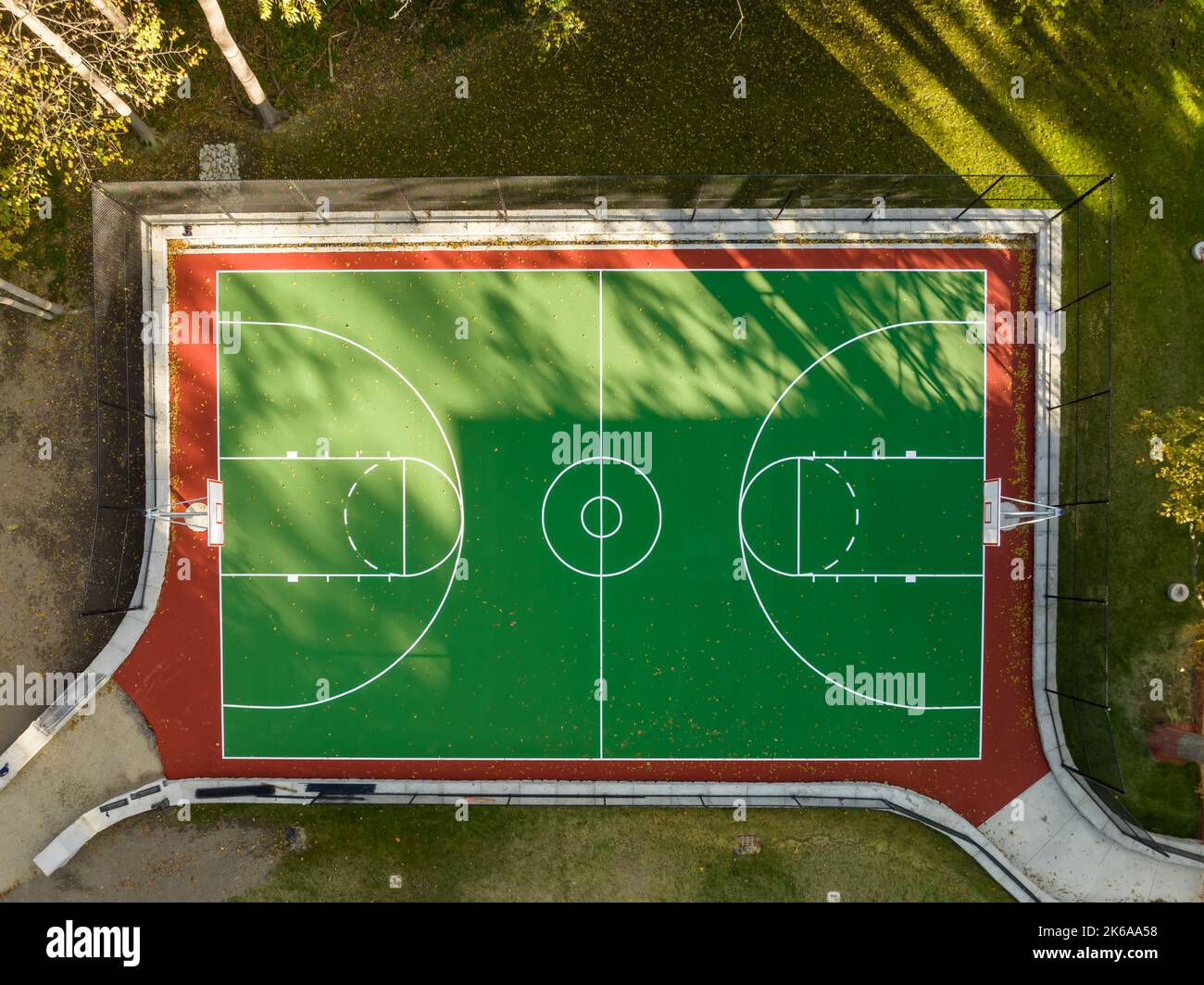 Interesting aerial photo of a green and red outdoor basketball court at