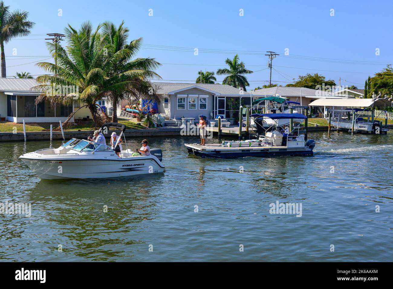 People on boats in boating community, on the canal near the marina and Phuzzy's boat shack restaurant and bar in Saint James City, Pine Island, FL Stock Photo