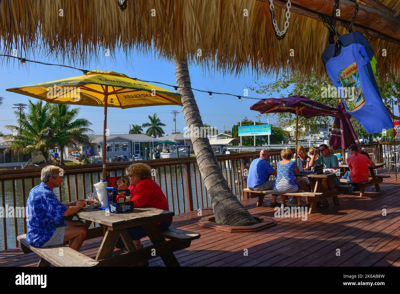 People enjoying outdoor dining on pier at Phuzzy's Boat Shack Restaurant on the canal in Saint James City, FL on Pine Island, before Hurricane Ian Stock Photo