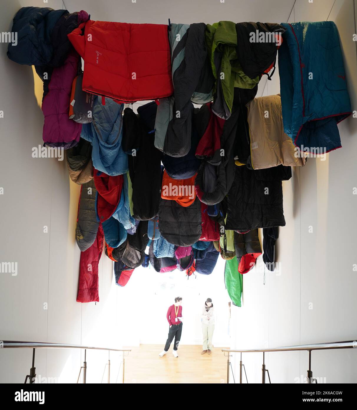 Hamburg, Germany. 11th Oct, 2022. 43 sleeping bags hang as an installation in the stairwell in front of the exhibition 'Who's Next? Homelessness, Architecture and the City' at the Museum für Kunst und Gewerbe. The sleeping bags symbolize the total of 43 dead homeless people in Hamburg in 2021. The show explores the question of how architectural solutions can improve the lives of homeless people and presents numerous international examples. Credit: Marcus Brandt/dpa/Alamy Live News Stock Photo