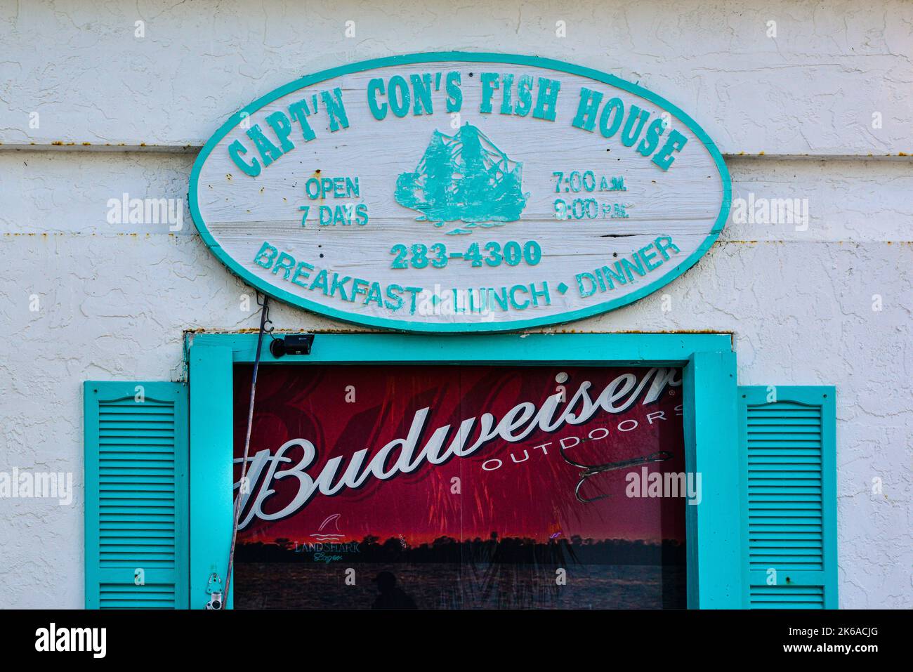 The turquoise and white sign above a window for Capt'n Con's FIsh House in Bokeelia, Florida, on Pine Island in Southwest Florida's Old style Stock Photo