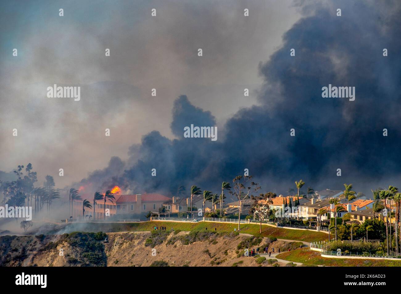 A wind driven brush fire burns hilltop homes in Laguna Niguel, CA. Stock Photo