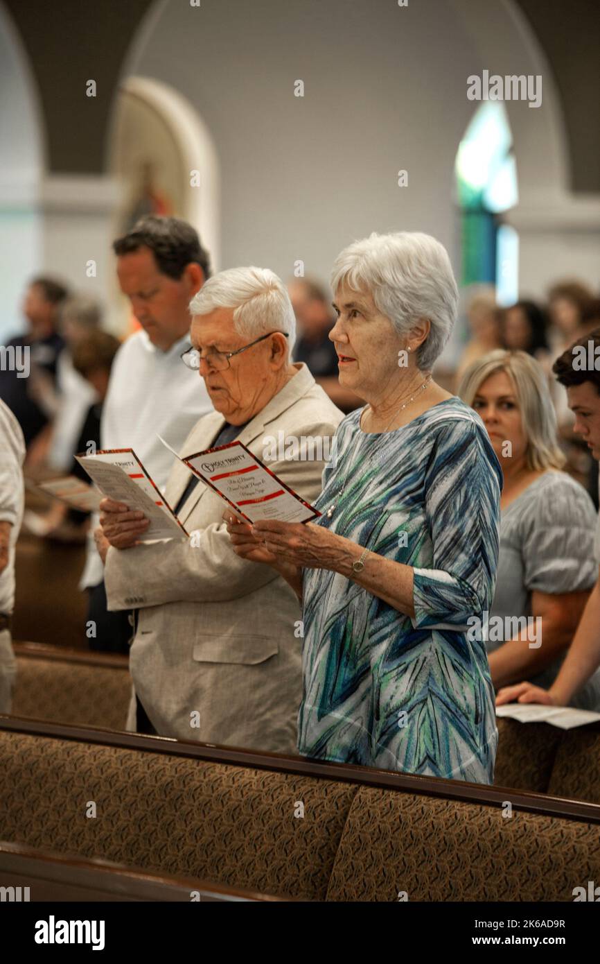 Parishioners at a Southern California Catholic church  read the lyrics to a hymn as they sing during mass. Stock Photo