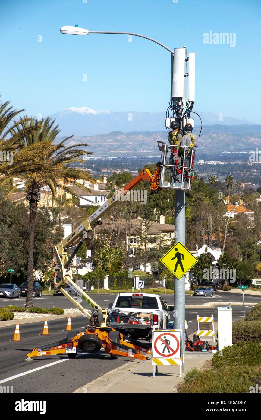 Using a portable cherry picker crane, maintenance workers repair a