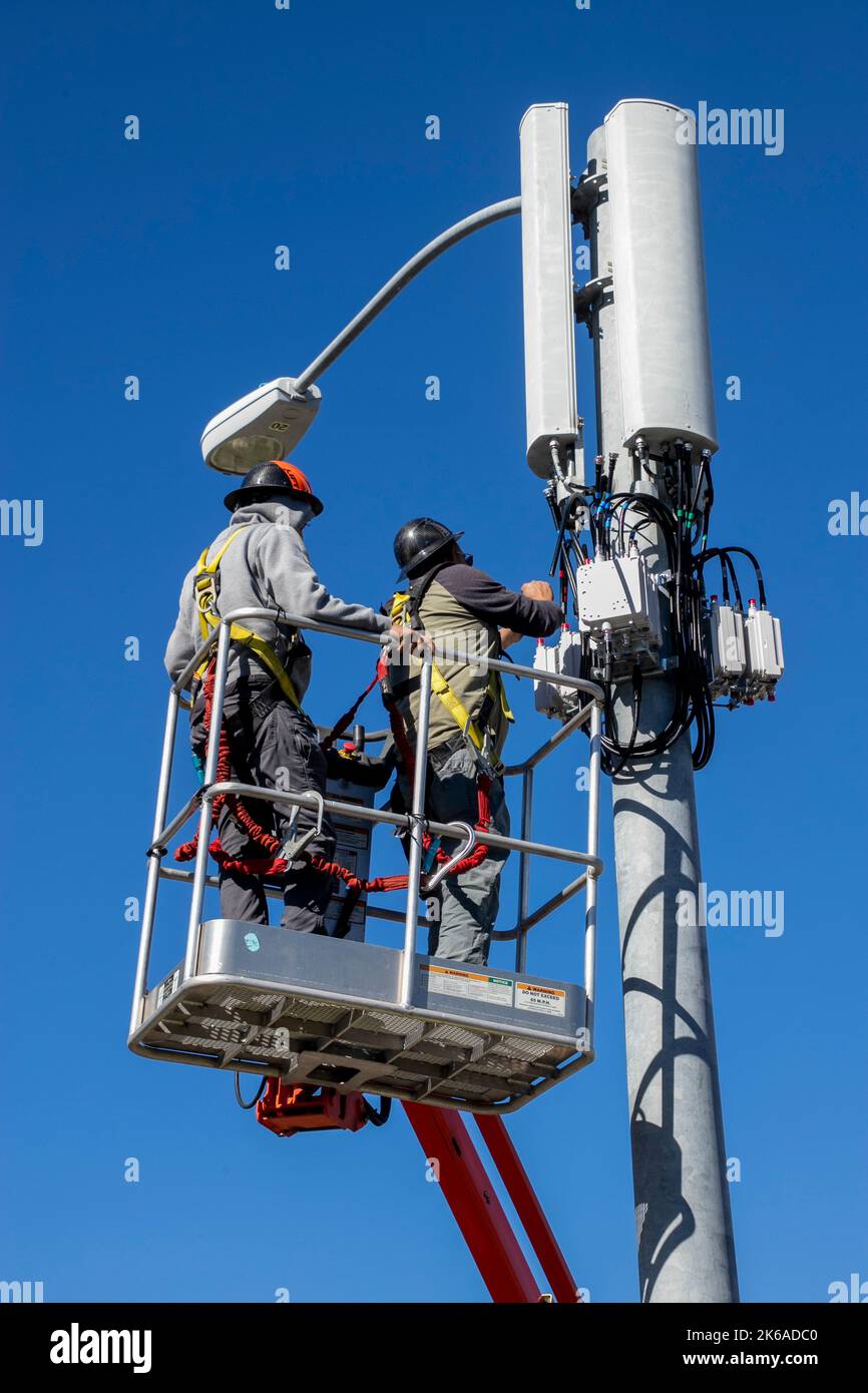 Using a portable cherry picker crane, maintenance workers repair a