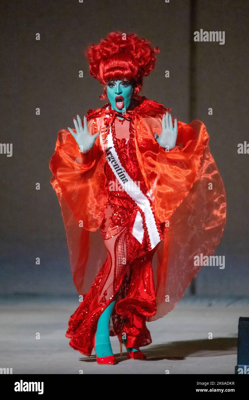 A transvestite performer in a drag queen show entertains an audience in