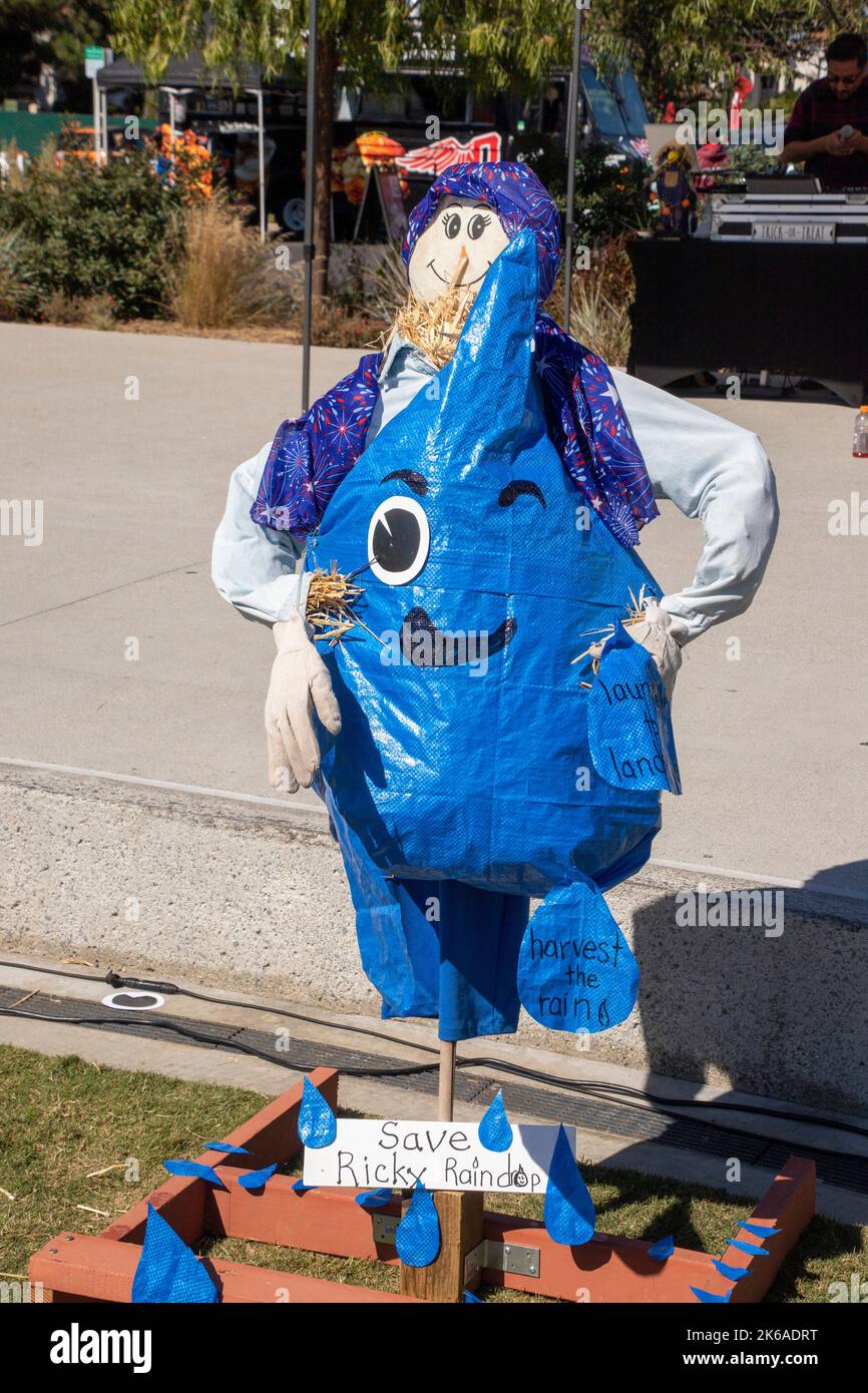 Promoting water conservation, a smiling scarecrow displays a stylized raindrop at a Halloween festival in a Costa Mesa, CA, park. Stock Photo