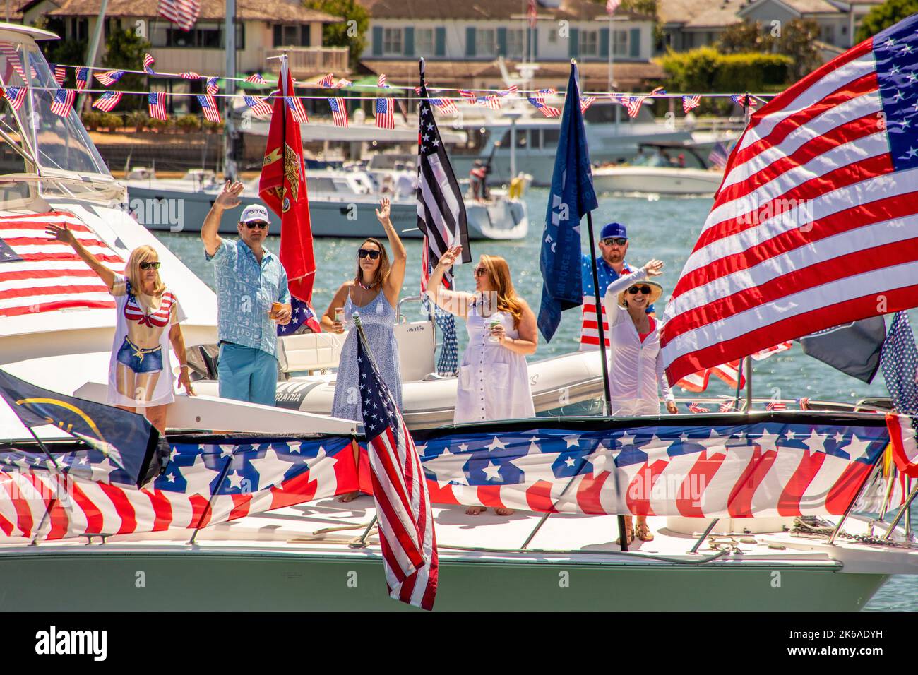 Boat crew and passengers are surrounded by US flags and bunting at a