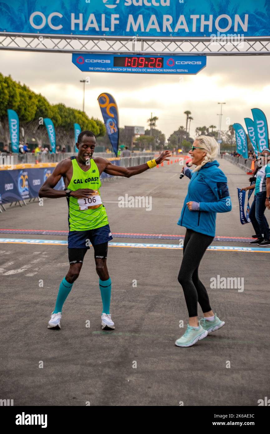 Having finished a half marathon, an African American runner does an impromptu celebratory dance in Costa Mesa, CA. Note timer at top. Stock Photo
