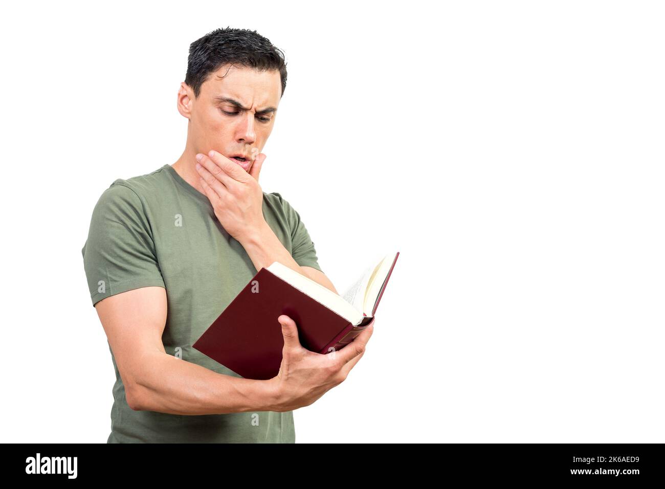 Thoughtful man touching chin and reading book Stock Photo