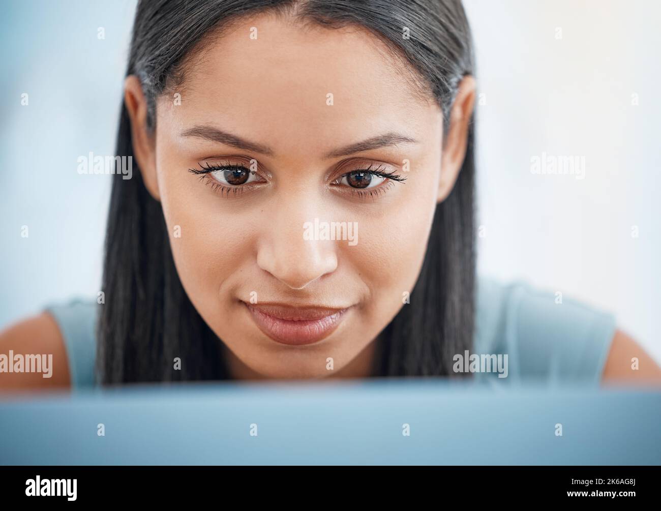 Happy young mixed race businesswoman focused while working on a laptop