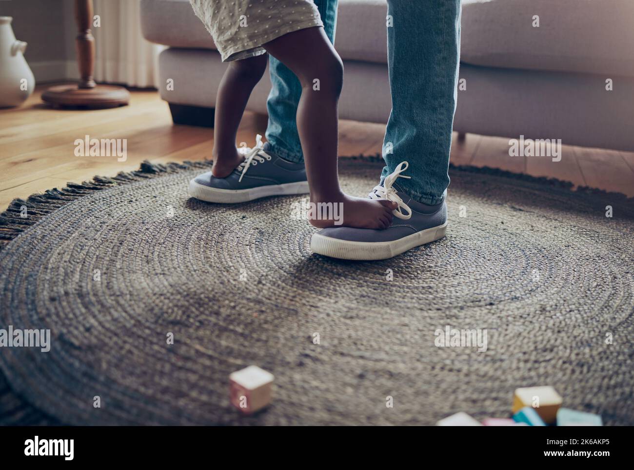 My first dance instructor. an unrecognizable parent and child dancing together at home. Stock Photo
